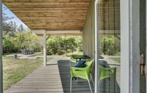 a porch with green chairs and a table at Holiday Home Ingeborgvej Løkken Iv in Grønhøj +20 photos