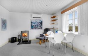 un soggiorno con tavolo, sedie e camino di Cozy Home In Stubbekbing With Kitchen a Stubbekøbing