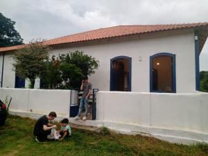 um homem e uma criança brincando com um cão em frente a uma casa em Bonserá do Madeira em Lavras