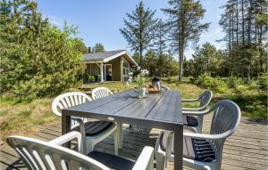 a table and chairs on a deck with a cabin at Holiday Home Ingeborgvej Løkken Iv in Grønhøj