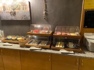 a buffet line with trays of food on a counter at Hotel Erika in Arzl im Pitztal +23 photos