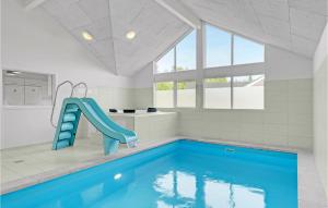 ティスヴィレライにあるNice Home In Tisvildeleje With Private Swimming Pool, Can Be Inside Or Outsideの家屋内の青い滑り台付きスイミングプール