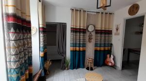 Cette chambre dispose de rideaux colorés et d'une guitare. dans l'établissement Le clos du poète, à Bourges