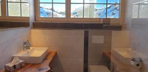 a bathroom with two sinks and a window at Pongitzerhof in Matrei in Osttirol