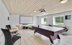 Habitación con mesa, sillas y pantalla. en Stunning Home In Jgerspris With 6 Bedrooms And Wifi, en Frederikssund
