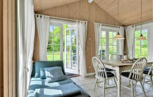 SpodsbjergにあるBeautiful Home In Rudkbing With Wifiのダイニングルーム(テーブル、椅子、窓付)