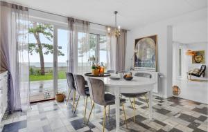 a dining room with a white table and chairs at Beach Front Home In Slagelse With Kitchen in Lille Kongsmark