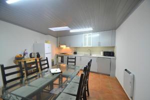 eine Küche mit einem Glastisch und Stühlen in der Unterkunft Carmonas 32 Hill in São Martinho do Porto