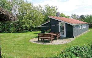a picnic table and bench in front of a shed at Holiday Home Sandvigvej Lundby Ii in Svinøvester