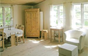 a living room with a table and a chair and windows at Holiday Home Sandvigvej Lundby Ii in Svinøvester +7 photos