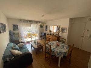 sala de estar con sofá azul y mesa en Appartement à Belz proche de la mer, en Belz