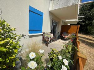 una casa con una puerta azul y algunas flores en Appartement à Belz proche de la mer, en Belz
