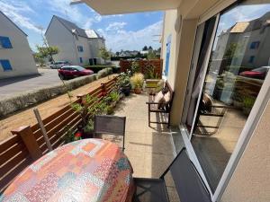 patio con mesa y sillas en el balcón en Appartement à Belz proche de la mer, en Belz