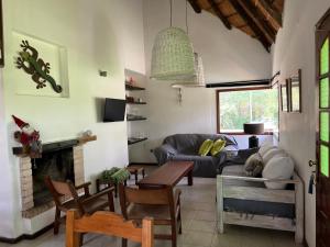 ein Wohnzimmer mit Couch und Kamin in der Unterkunft CASA MARÍTIMA EN PORTEZUELO, MALDONADO, URUGUAY in Punta del Este