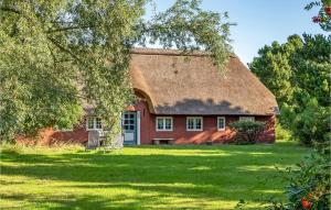 een rood bakstenen huis met een rieten dak bij Stunning Home In Rm With Wifi in Bolilmark