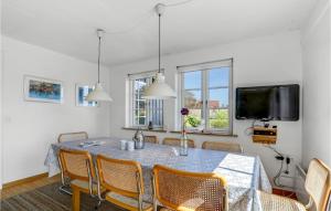 comedor con mesa con sillas y TV en Amazing Home In Gudhjem With 4 Bedrooms And Wifi, en Gudhjem