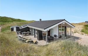 a house on top of a beach with some chairs at Amazing Home In Hvide Sande With 4 Bedrooms, Sauna And Wifi in Hvide Sande