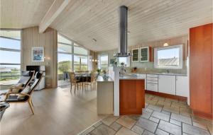 a kitchen and dining room with a table and chairs at Amazing Home In Hvide Sande With 4 Bedrooms, Sauna And Wifi in Hvide Sande