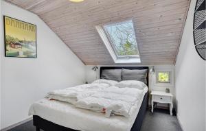 a bedroom with a bed in a attic with a window at Three-Bedroom Holiday Home In Dannemare in Dannemare