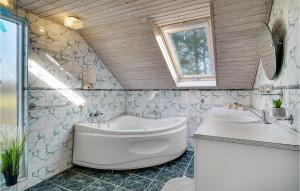 a bathroom with a tub and a toilet and a sink at Three-Bedroom Holiday Home In Dannemare in Dannemare