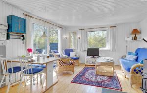 KramnitseにあるBeautiful Home In Rdby With Kitchenのリビングルーム(テーブル、青い椅子付)