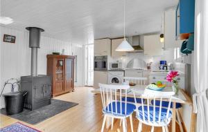 a kitchen with a table and chairs and a stove at Holiday Home Sneppevej Rødby Denm in Kramnitse