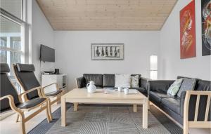 a living room with a couch and a table and chairs at 3 Bedroom Nice Home In Hasle in Tofte