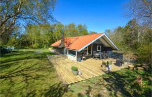 a house with a wooden deck in a yard at Nice Home In Thyholm With 4 Bedrooms, Sauna And Wifi in Thyholm
