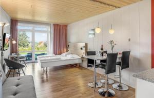 Stunning Apartment In Allinge With Wifi في إلينغه: غرفة معيشة مع سرير وطاولة وكراسي
