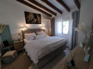 Un dormitorio con una cama grande y una ventana en Casa Wens Bénimeit, en Moraira