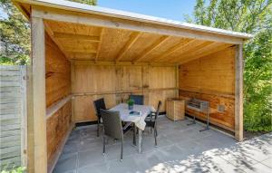 un padiglione in legno con tavolo e sedie su un patio di 1 Bedroom Cozy Home In Nrre Nebel a Nymindegab