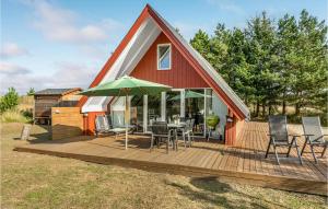 ein Haus mit einer Terrasse mit einem Tisch und Stühlen in der Unterkunft Amazing Home In Rm With 3 Bedrooms And Wifi in Toftum