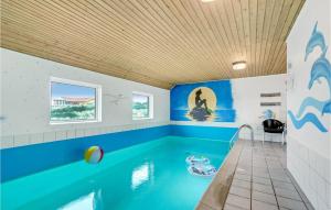 バイアス・スタンにあるAwesome Home In Vejers Strand With Wifi, Private Swimming Pool And Indoor Swimming Poolの青い壁と木製の天井の家のプール