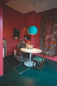 a table and chairs in a room with red walls at Retreat midden op de Veluwe -ingang Park 1 km in Hoenderloo