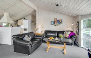 een woonkamer met een leren bank en een tafel bij Holiday Home Ringvejen Rømø Denm in Bolilmark
