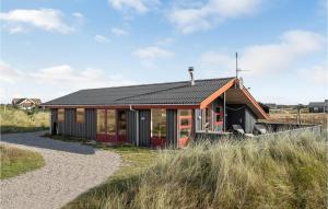 BjerregårdにあるLovely Home In Hvide Sande With Saunaの海辺の黒屋根の小屋