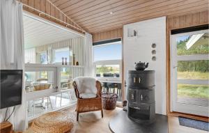 SønderhoにあるStunning Home In Fan With 4 Bedrooms, Sauna And Indoor Swimming Poolのリビングルーム(薪ストーブ、テーブル付)