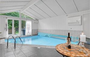 Nørre NebelにあるBeautiful Home In Nrre Nebel With Indoor Swimming Poolのスイミングプール(テーブル、ワイン1本付)