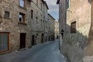 un callejón en un casco antiguo con edificios de piedra en Residenza San Leonardo - Viterbo Centro Storico, en Viterbo
