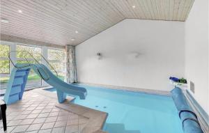 JerupにあるAwesome Home In Jerup With 4 Bedrooms, Sauna And Private Swimming Poolの家屋内の滑り台付きスイミングプール