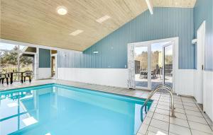 una piscina in una casa con pareti blu di Nice Home In Vejers Strand With Kitchen a Vejers Strand