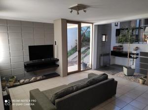 sala de estar con sofá y TV de pantalla plana en Triplex de diseño , amplio , luminoso y céntrico en Carmen de Patagones