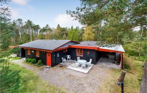 uma pequena casa vermelha e preta na floresta em Amazing Home In Jerup With 2 Bedrooms And Wifi em Jerup