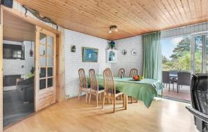 a dining room with a green table and chairs at Four-Bedroom Holiday Home In Romo in Tagholm