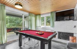 a ping pong table in a room with a fireplace at Four-Bedroom Holiday Home In Romo in Tagholm +18 photos
