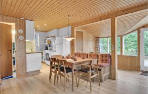a kitchen and dining room with a table and chairs at Two-Bedroom Holiday Home In Saby in Sæby