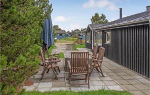 a patio with chairs and a table and an umbrella at Two-Bedroom Holiday Home In Saby in Sæby +20 photos