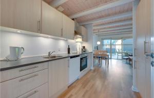 a kitchen with white cabinets and a wooden floor at Hus R in Henne Strand