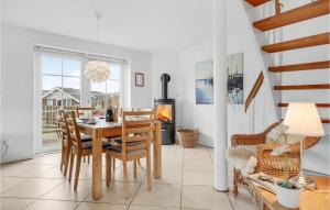 a dining room with a table and a fireplace at Cozy Home In Rm With House Sea View in Rømø Kirkeby
