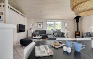 a living room with a couch and a table at Stunning Home In Blokhus With 3 Bedrooms, Sauna And Wifi in Blokhus